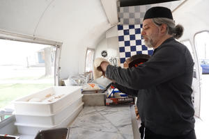 Photo inside Airstream of Barry stretching pizza dough