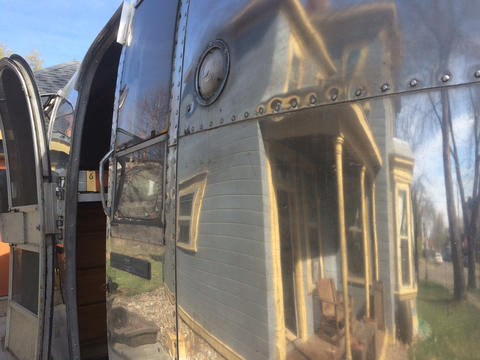 Photo showing reflected image of our house on the side of the Airstream trailer