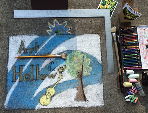Art in the Hollow logo with tree, brush, violin drawn in chalk on ground with chalk in picture