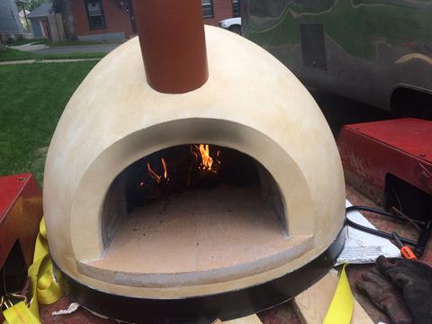 Photo of wood-fire oven with chimney on trailer